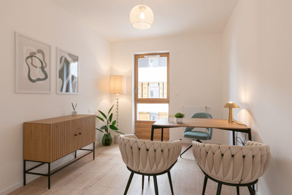 Bureau aménagé dans un appartement contemporain à Nancy, avec deux fauteuils, buffet en bois et lumière naturelle